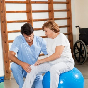 therapist-examining-senior-womans-knee therapist-examining-senior-womans-knee